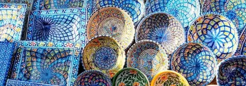 Mehrere kunstvoll verzierte Keramikteller und -schalen mit geometrischen Mustern auf einem Markt in Sidi Bou Said.