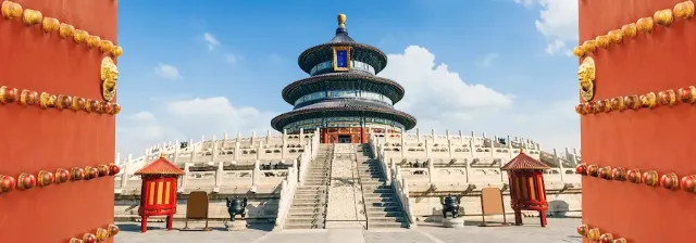 Blick durch zwei geöffneten roten Toren auf den Himmelstempel in Peking mit mehreren Dachebenen.