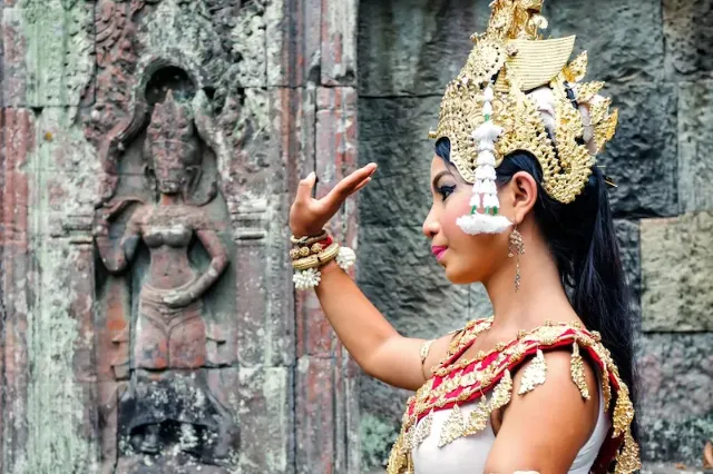 Khmer-Apsara-Tänzerin mit traditioneller Tracht tanzt in einer Tempelanlage.