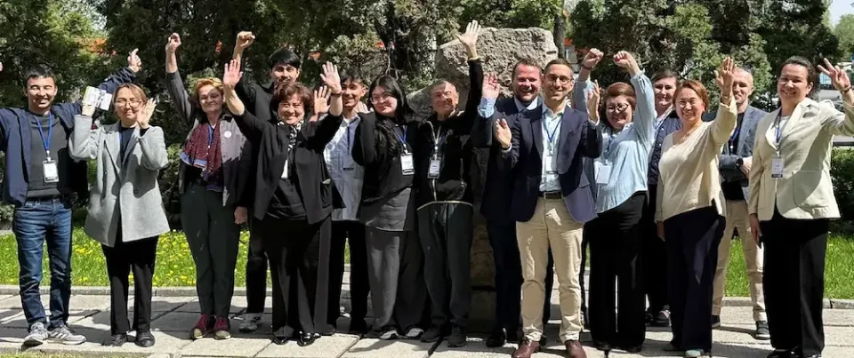 Ein Gruppenbild draußen in der Sonne mit den Teilnehmern eines Workshops.