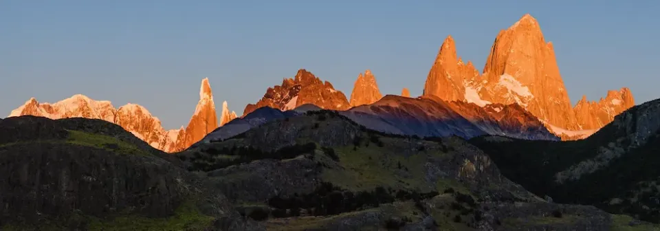 Erste Sonnenstrahlen fallen auf das Bergmassiv rund um den Berg Fitz Roy in Patagonien.