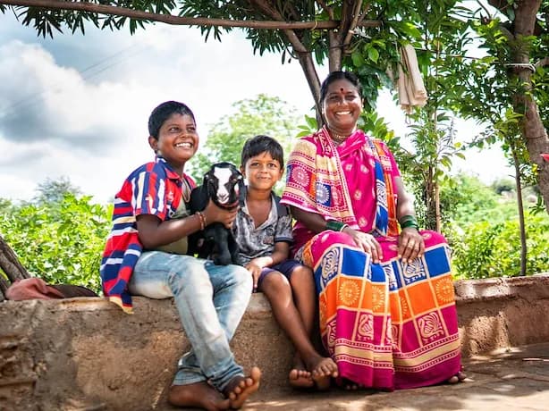 Eine Frau mit zwei Kindern in bunten Gewändern.