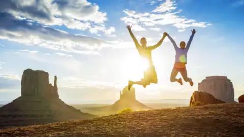 Junge Traveller springen freudig in die Luft vor dem Hintergrund des Monument Valley, ein Highlight dieser Rundreise durch den Westen der USA.