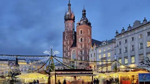 Zwischen Lichterglanz, Holzbuden und dem Duft von Zimt und Mandeln, wärmen wir uns auf dem Weihnachtsmarkt in Krakaus Altstadt mit einem heißen Grzaniec, polnischen Glühwein, auf.