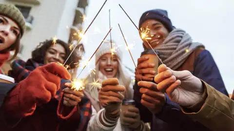 Eine Gruppe junger Reisender feiert mit Wunderkerzen Silvester in Helsinki