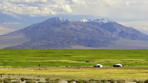 Jurten in einer malerischen Umgebung mit Bergen und Wolken
