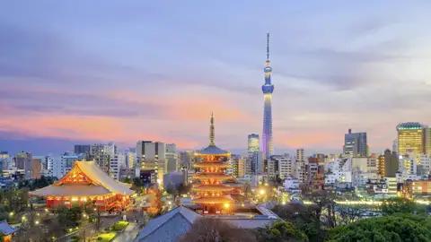 Abenddämmerung in Tokio mit Blick auf die beleuchtete Pagode des Senso-ji-Tempels und den hoch aufragenden Tokyo Skytree.