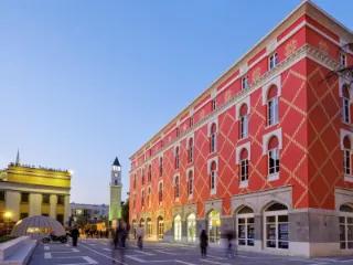 Ein rotes Gebäude mit eleganter Fassade in der Innenstadt von Albaniens Hauptstadt Tirana.