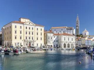 Blick auf den Hafen von Piran in Slowenien mit historischen Gebäuden und Booten.