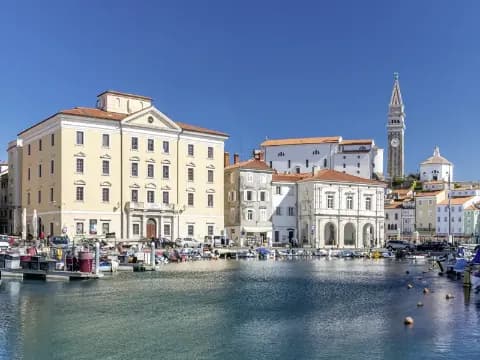 Blick auf den Hafen von Piran in Slowenien mit historischen Gebäuden und Booten.