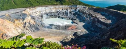 Ein dampfender Geysir in einer kargen Landschaft im Nationalpark Poás