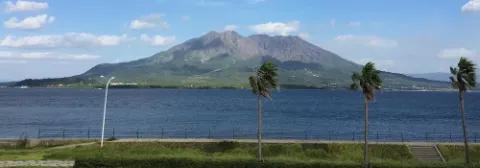 Blick auf den Vulkan Sakurajima auf der gleichnamigen Insel mitten im blauen Meer