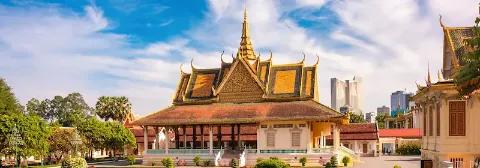 Königspalast in Phnom Penh mit reich verziertem, goldenen Dach und mehreren Türmen vor blauem Himmel.