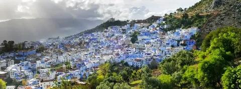 Blick auf die Stadt Chefchaouen mit ihren berühmte bauen Häusern, gelegen am grünen Berghang