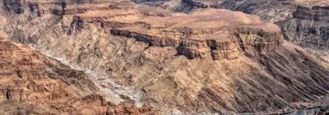 Ausblick über den Fish River Canyons mit schroffen Felsformationen unter leicht bewölktem Himmel.