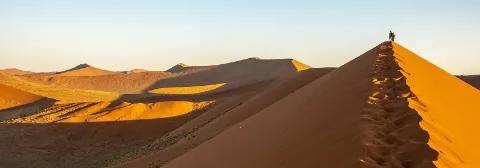 Zwei Personen wandern auf der Big Daddy Dune in der Namib-Wüste