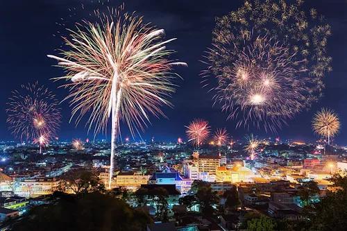 Über der Stadt geht ein farbenfrohes Silvester-Feuerwerk in den Himmel.
