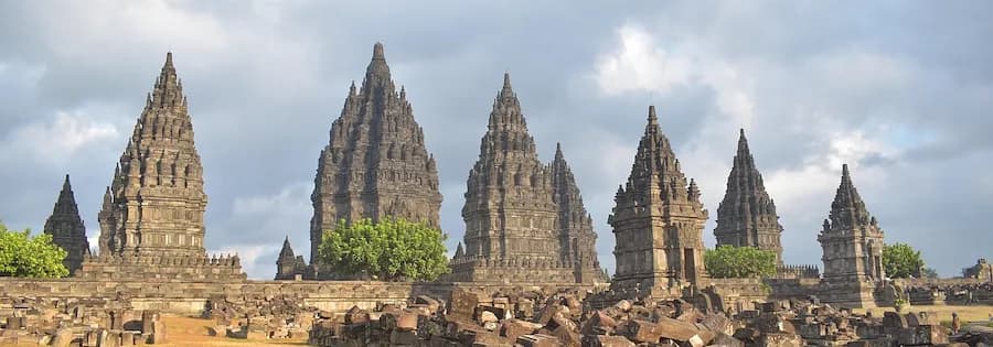 Blick auf die beeindruckenden Tempelruinen von Prambanan mit markanten Türmen und üppigem Grün.