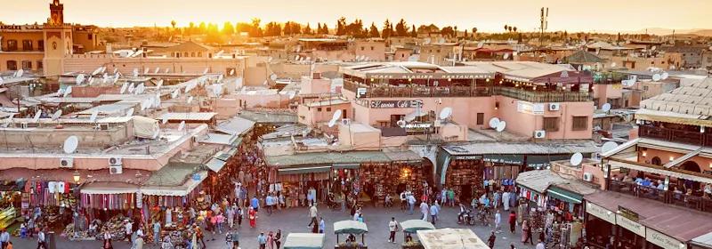 Blick über Marrakesch und den berühmten Markt Djemaa el-Fna bei Sonnenuntergang