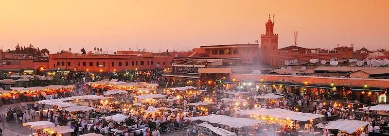 Blick über Marrakesch und den berühmten Markt Djemaa el-Fna bei Sonnenuntergang