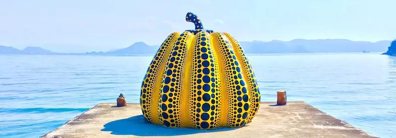 Kunstattraktion Goldener Kürbis auf einem Steg direkt am Ufer der Insel Naoshima