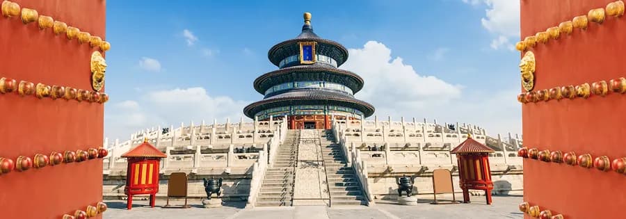 Blick durch zwei geöffneten roten Toren auf den Himmelstempel in Peking mit mehreren Dachebenen.