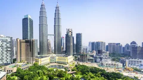 Auf Ihrer Reise sehen Sie die ikonischen Petronas Twin Towers. Sie ragen über die Skyline von Kuala Lumpur, der weitläufige KLCC Park liegt im Vordergrund.