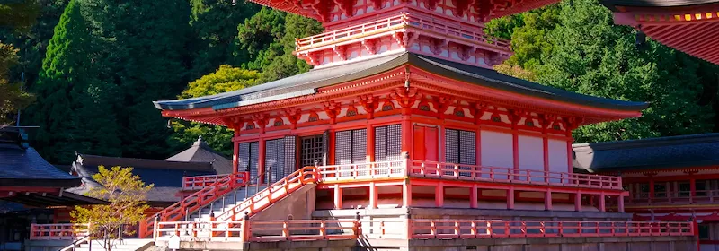 Roter Hieisan Enryaku-ji Tempel in Kyoto,  umgeben von üppigen grünen Bäumen.