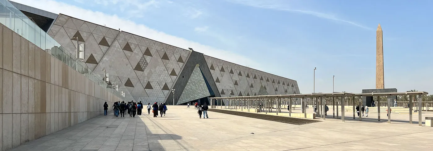 Das Ägyptische Museum in Gizeh mit moderner Architektur und einem Obelisken, umgeben von Besuchern.