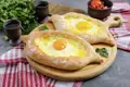 Auf unserer Marco Polo Rundreise durch Georgien backen wir gemeinsam Chatschapuri in einem Kaukasusdorf. Die georgische Pizza ist so lecker, dass man sich gar nicht daran satt essen kann.