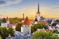Auf Ihrer Entdecker-Rundreise durch das Baltikum erkunden Sie die Altstadt von Tallinn mit Türmen und St. Olaikirche bei Sonnenuntergang.
