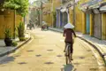 Auf Ihrer Reise sehen Sie Einheimische mit traditionellen Hüten beim Fahrradfahren durch die Altstadt von Hoi An.