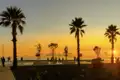 Bei unserer Rundreise genießen wir einen atemberaubenden Sonnenuntergang an der palmengesäumten Promenade von Durres an der Adriaküste.