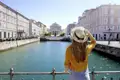 Reisende am Kanal mit Blick auf die Stadt Triest. Auch Sie haben bei Ihrer Reise Gelegenheit eine Blick zu wagen.