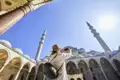 Eine Frau fotografiert während einer im Reiseverlauf inkludierten Besichtigung die beeindruckenden Kuppeln und Minarette der Blauen Moschee in Istanbul, ein Highlight dieser Top-Preis-Reise.