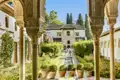 Ein Highlight auf unserer Rundreise durch Andalusien: Die kunstvollen Bögen und Säulen der Alhambra rahmen den Blick auf den Garten und den Brunnen ein.