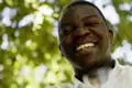 Ein Afrikaner, lachend vor Weinreben