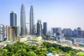 Auf Ihrer Reise sehen Sie die ikonischen Petronas Twin Towers. Sie ragen über die Skyline von Kuala Lumpur, der weitläufige KLCC Park liegt im Vordergrund.