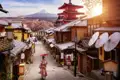 Malerische Gasse in Japan: Frau im Kimono mit Schirm, im Hintergrund rote Pagode, Kirschblüten und der heilige Berg Fuji.