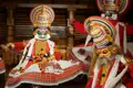 Aufführung eines Kathakali-Tanzes in Kochi  bei dem die Tänzer in bunte Kostüme mit verzierten Masken gekleidet sind.