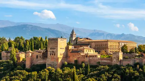 Auf Ihrer individuellen Rundreise im Mietwagen durch Andalusien haben Sie einen Panoramablick auf die Alhambra mit ihren Türmen, Mauern und Gebäuden, eingebettet in die Landschaft der Sierra Nevada.