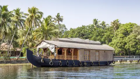 Traditionelles Hausboot steht am Ufer in den Backwaters von Kerala.