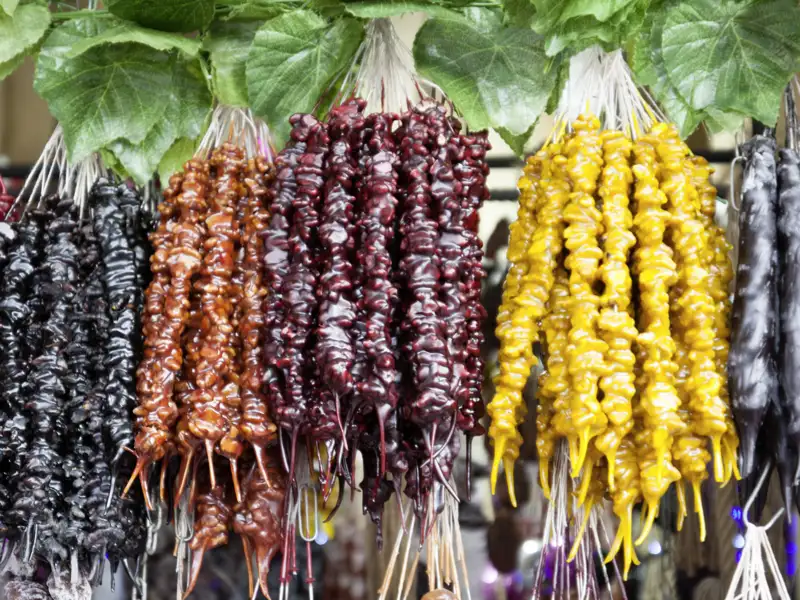 Georgien ist ein Paradies für Foodies. Und Tschurtschchela, mit Traubensaft überzogene Haselnüsse und Walnüsse, sind der beliebteste Snack für zwischendurch - unbedingt probieren!