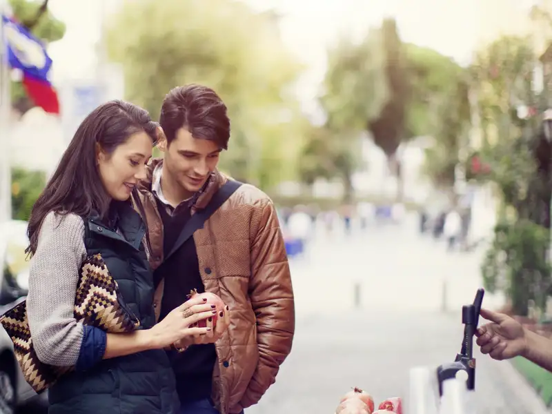 Paar an einer Saftbar mit Granatapfelsaft.