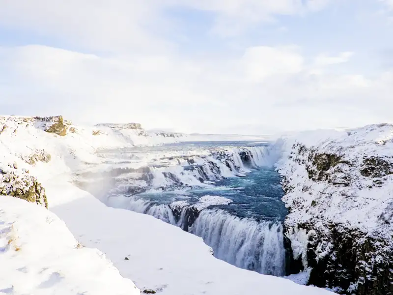 Auf unserer YOUNG LINE Rundreise im Winter durch Island besuchen wir den mächtigen Gullfoss, auch bekannt als der „Goldene Wasserfall".