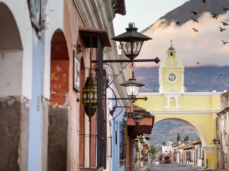 Erlebe auf unserer YOUNG LINE TRAVEL Rundreise durch Guatemala die koloniale Pracht Antiguas: kopfsteingepflasterte Straßen, farbenfrohe Fassaden und eindrucksvolle Kirchen und Klöster vor der Kulisse der gewaltigen Vulkane Agua, Fuego und Acatenango.
