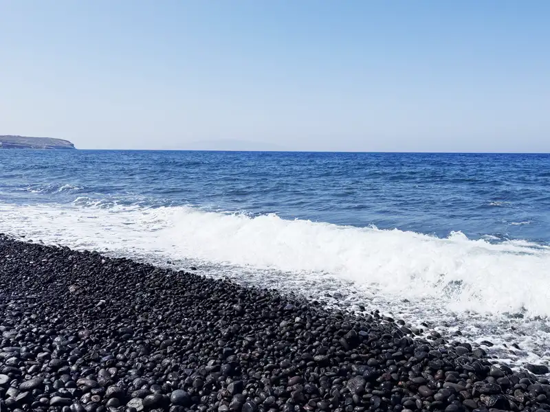 Auf unserer Kykladen-Rundreise ist auf Santorin Zeit zum Relaxen am schwarzen Vulkanstrand von Kamari.