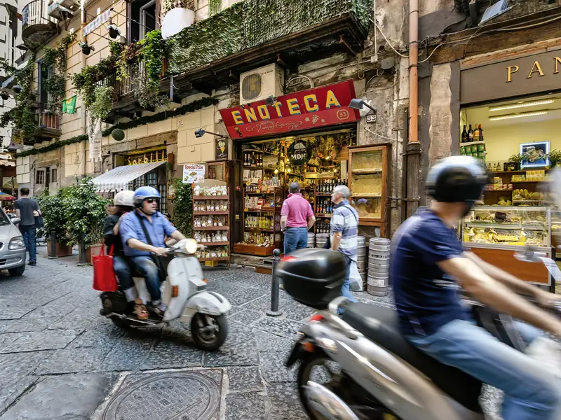Rollerfahrer, Weinhändler, Flaneure und Pizzabäcker sorgen in den Gassen von Neapel, einer Station auf unserer Reise an den Golf von Sorrent, für buntes Leben.