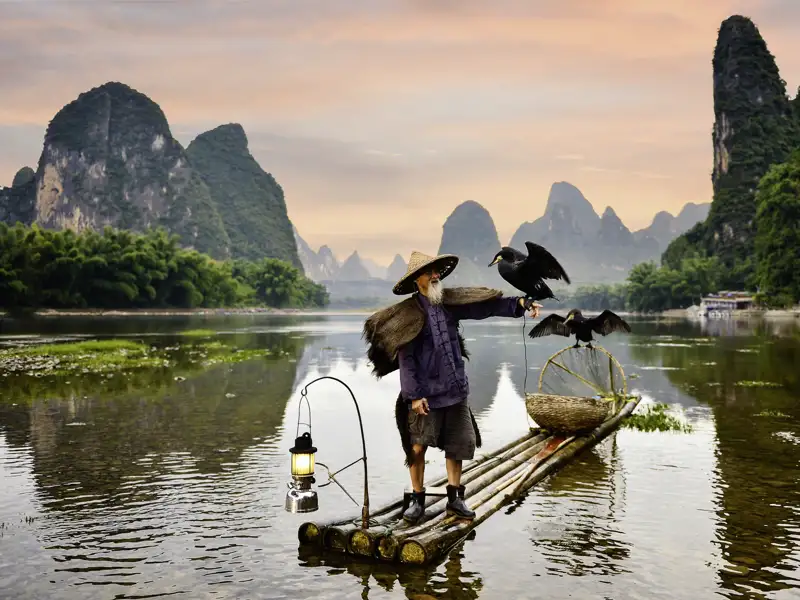 Bei unserer Marco Polo Reise in der kleinen Gruppe unternehmen wir eine Bootsfahrt durchs Märchenland. Wir schlängeln uns an Bambushainen und -hütten und dicht an den Steilwänden bizarrer Gipfel vorbei.