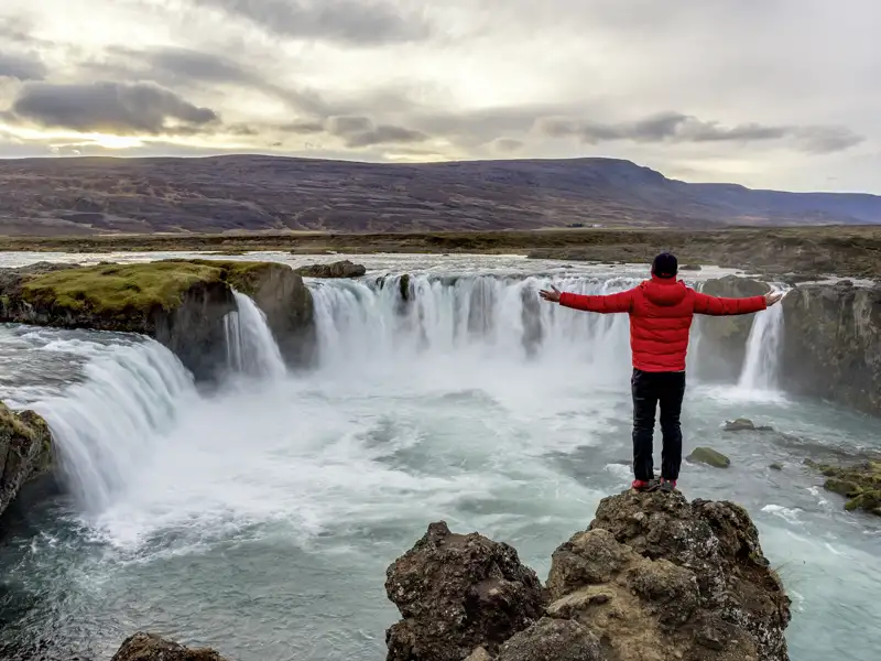 Auf unserer Rundreise durch Island kommen wir auf der Fahrt von Husavik nach Akureyri am Godafoss, einem der größten und beeindruckendsten Wasserfälle Islands, vorbei.